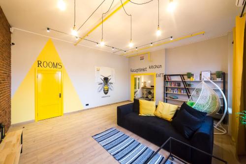 a living room with a black couch and a yellow door at HOTEL Bee Station in Kyiv