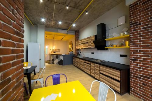 a kitchen with a table and chairs and a brick wall at HOTEL Bee Station in Kyiv