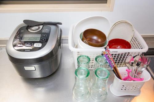 a kitchen counter with a toaster and glasses and utensils at City Center House Next to Subway Station in Kyoto