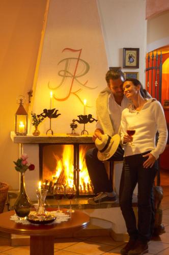 a man and a woman standing in front of a fireplace at Wohlfühlresort und Feriengut Martinerhof in Sankt Martin am Tennengebirge