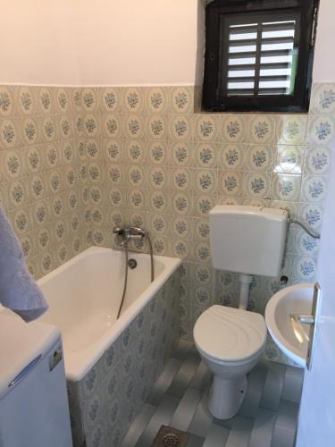 uma casa de banho com um WC, uma banheira e um lavatório. em Apartmani Jacqueline em Drage