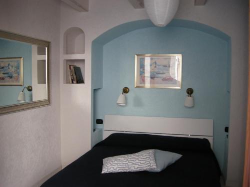 una camera da letto con un letto nero e una parete blu di I colori del mare a Carloforte