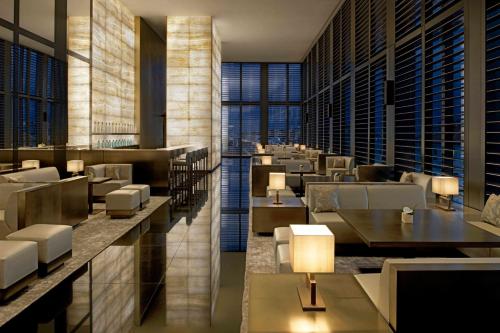 a restaurant with tables and chairs and windows at Armani Hotel Milano in Milan