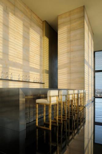 a dining room with a bar with stools at Armani Hotel Milano in Milan