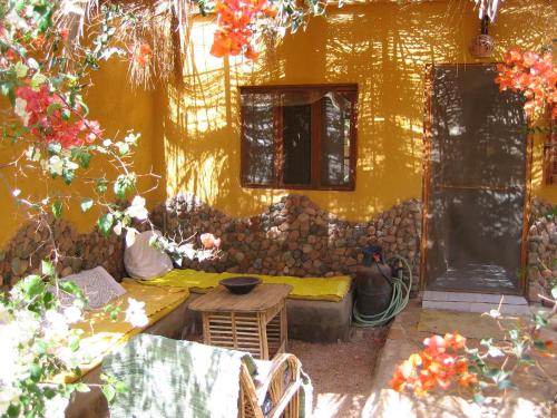 ein gelbes Gebäude mit einer Couch und einem Tisch davor in der Unterkunft Jillyfish House, deine Oase in zwei Palmengärten, central am 'Lighthouse' in Dahab