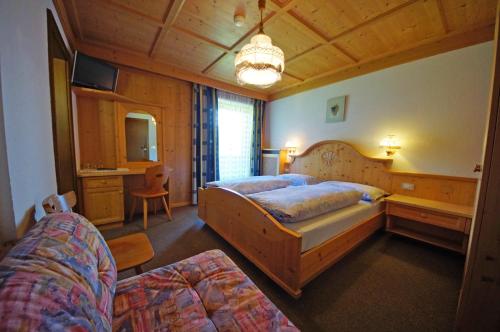 a bedroom with two beds and a desk in it at Pension Arnica B&B in San Vigilio Di Marebbe