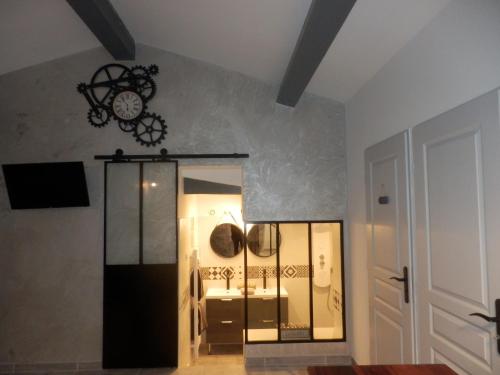 une chambre avec une horloge sur le mur dans l'établissement Gite Le city en Provence, à Lambesc