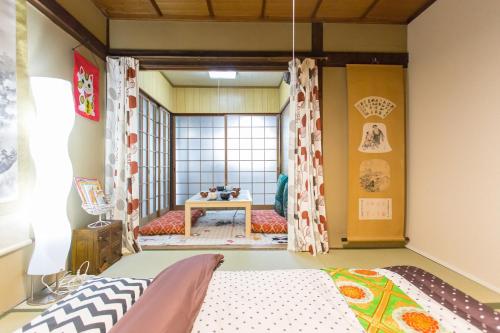 a room with a bed and a table at City Center 200 Years Old Traditional House Next to 2 Train Lines in Kyoto