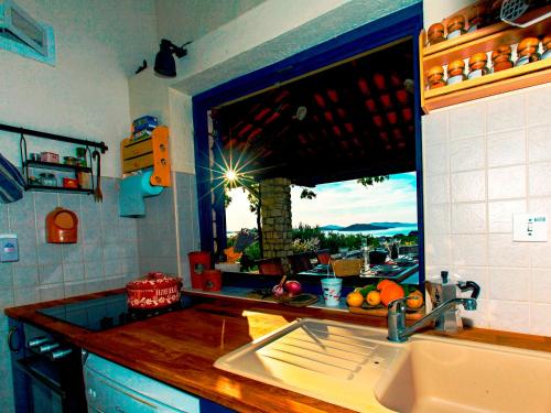 a kitchen with a sink and a window with a view at Holiday House Oh La La! in Zlarin