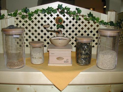 a shelf with four jars of spices and a sink at Bio-Bauernhof-Hotel Matlschweiger in Lassing