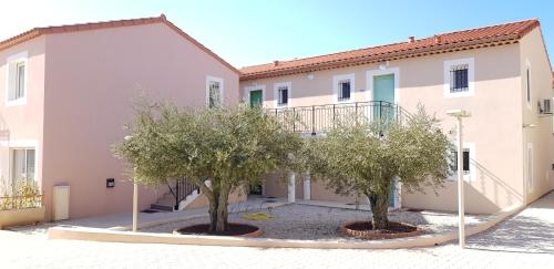 a house with two trees in front of it at Appart'hotel Résidence La Provence in Istres