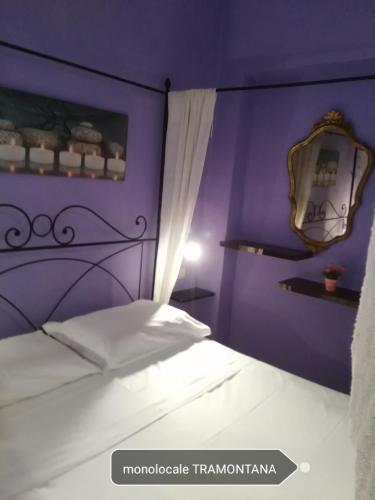 a bedroom with a bed with a purple wall at Villa Isabella in Marina di Grosseto
