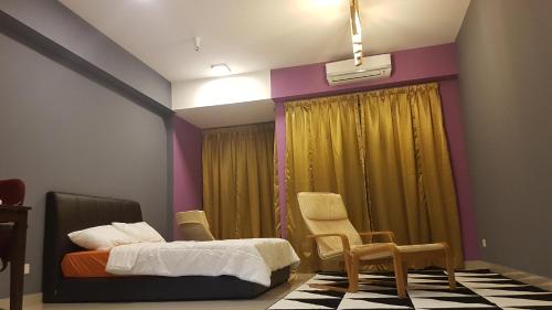 a bedroom with a bed and chairs and a window at Utropolis by MiRic in Shah Alam