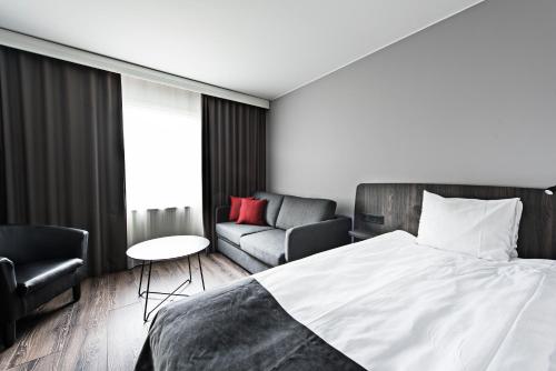 a bedroom with a bed and a chair and a couch at Best Western Karlshamn Spa & Relax in Karlshamn