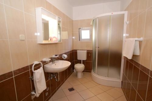 a bathroom with a shower and a toilet and a sink at Obala Apartment & Studios in Malinska