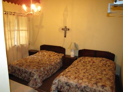 a bedroom with two beds and a cross on the wall at Los Aramos in Valle de Anton