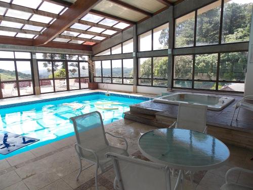 uma grande piscina com uma mesa e cadeiras e uma mesa em Apart-hotel em Gramado, padrão 4 estrelas, no centro em Gramado