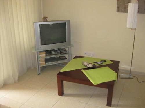 sala de estar con TV y mesa de centro en Pyla Village Resort F110 (Apartment near Larnaca), en Pyla