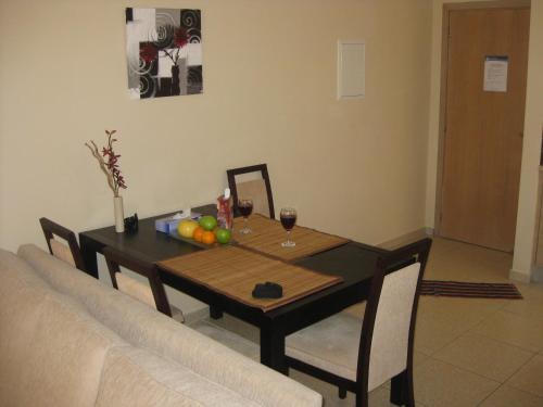 una mesa de comedor con una copa de vino y fruta. en Pyla Village Resort F110 (Apartment near Larnaca) en Pyla