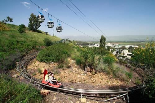 two people riding a ride on a roller coaster at Magical in the Galilee in Qiryat Shemona