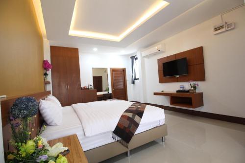 a hotel room with a bed and a television at Nonghan Grand Hotel and Resort in Nong Han
