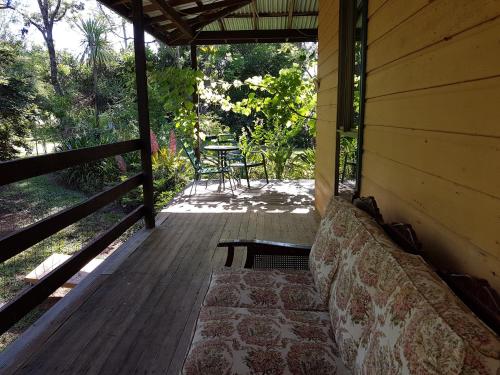 a porch of a house with a couch and a table at Freida - Historic Farmhouse Bellingen in Gleniffer