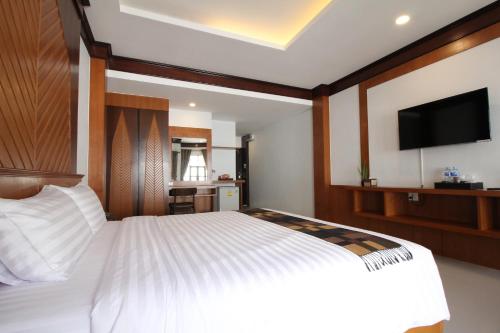 a bedroom with a white bed with a flat screen tv at Nonghan Grand Hotel and Resort in Nong Han
