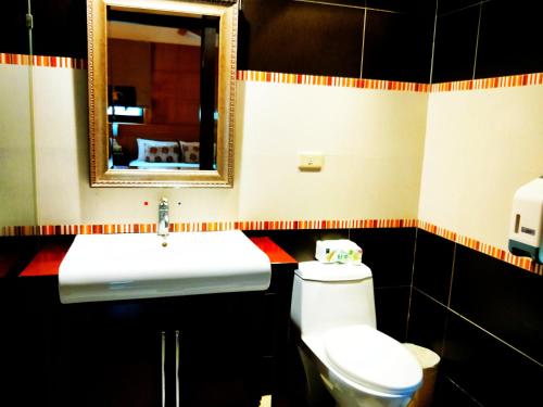 a bathroom with a sink and a toilet and a mirror at Borabora B&B in Nanwan