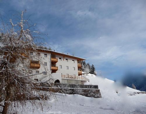 a building on a snow covered hill with snow at Putzerhof in Funes