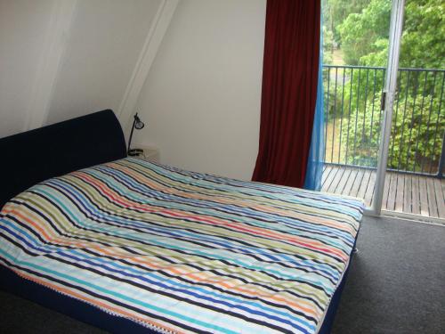 a bedroom with a bed with a colorful blanket on it at Ageri Holiday House in Bright