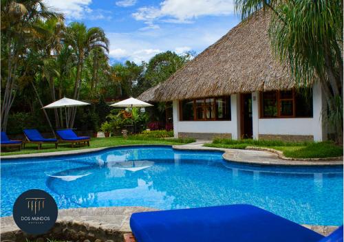 a resort swimming pool with blue chairs and a building at Hotel Dos Mundos Panajachel in Panajachel