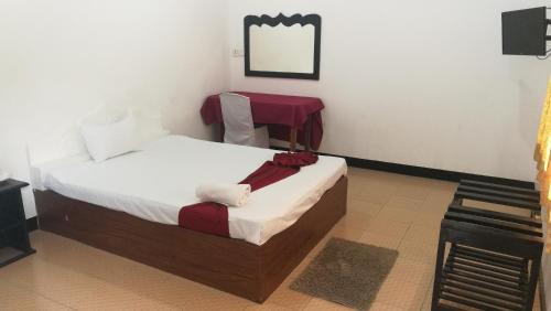 sypialnia z łóżkiem i lustrem na ścianie w obiekcie Friends Paradise w mieście Kilinochchi