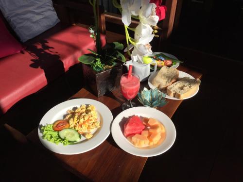 a wooden table with three plates of food on it at Ratna Villa 4 in Ubud
