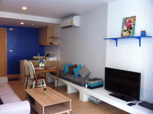 Una sala de estar con un sofá, un televisor y una mesa. en BanSanKram by Patsara, en Cha Am