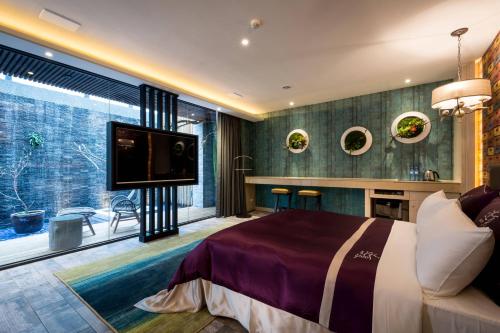 a bedroom with a large bed and a flat screen tv at Shu Jia Motel in Taichung