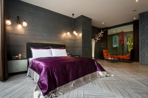 a bedroom with a large bed with a purple blanket at Shu Jia Motel in Taichung