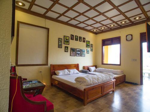 a bedroom with a large bed and a table at Dong Van B&B in Dồng Văn