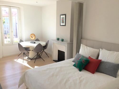 1 dormitorio con 1 cama con chimenea y mesa en Bright & modern apartment in the heart of Antibes, en Antibes