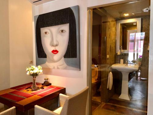 a bathroom with a painting of a woman with red lipstick at Baipho Lifestyle in Patong Beach