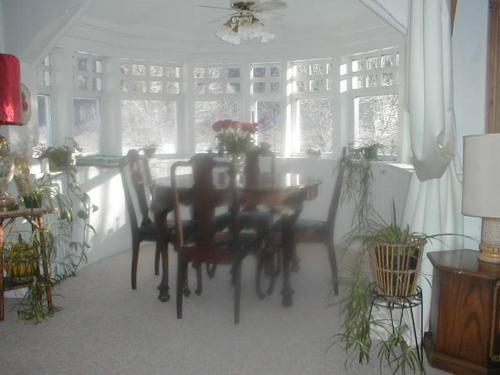 a dining room with a table and chairs and windows at Mountain Valley Retreat in Killington