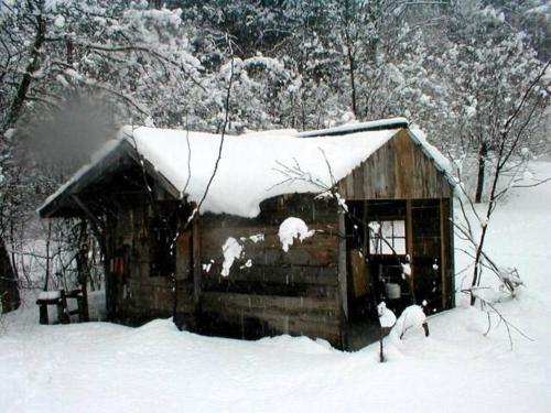 a small wooden cabin with snow on the roof at Mountain Valley Retreat in Killington