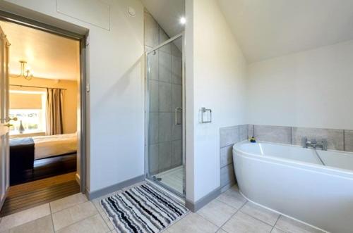 a bathroom with a bath tub and a shower at Wrens Nook in St. Agnes 