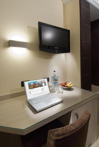 a laptop computer sitting on a desk with a tv at Hotel Imperial in San Benedetto del Tronto