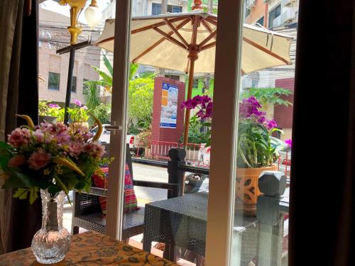 a table with a vase of flowers and an umbrella at Baipho Lifestyle in Patong Beach