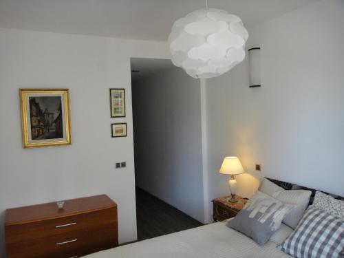 sypialnia z łóżkiem i lampką na ścianie w obiekcie Chambres Mountain w mieście Poiana Brașov