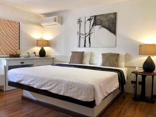 a bedroom with a large white bed and a desk at Baipho Lifestyle in Patong Beach