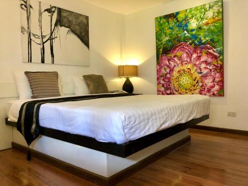 a bedroom with a bed with a painting on the wall at Baipho Lifestyle in Patong Beach