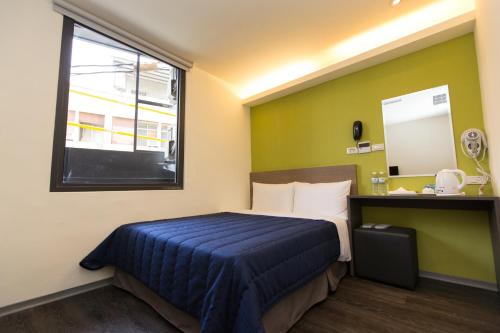 a bed in a room with a window and a bed sidx sidx sidx at Bulowan Hotel in Hualien City