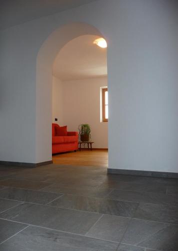 a living room with a red couch and a wall at Putzerhof in Funes