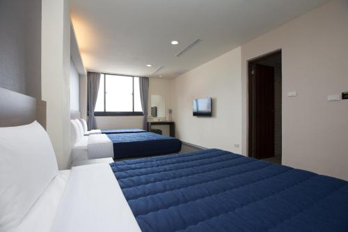 two beds in a room with blue and white at Bulowan Hotel in Hualien City